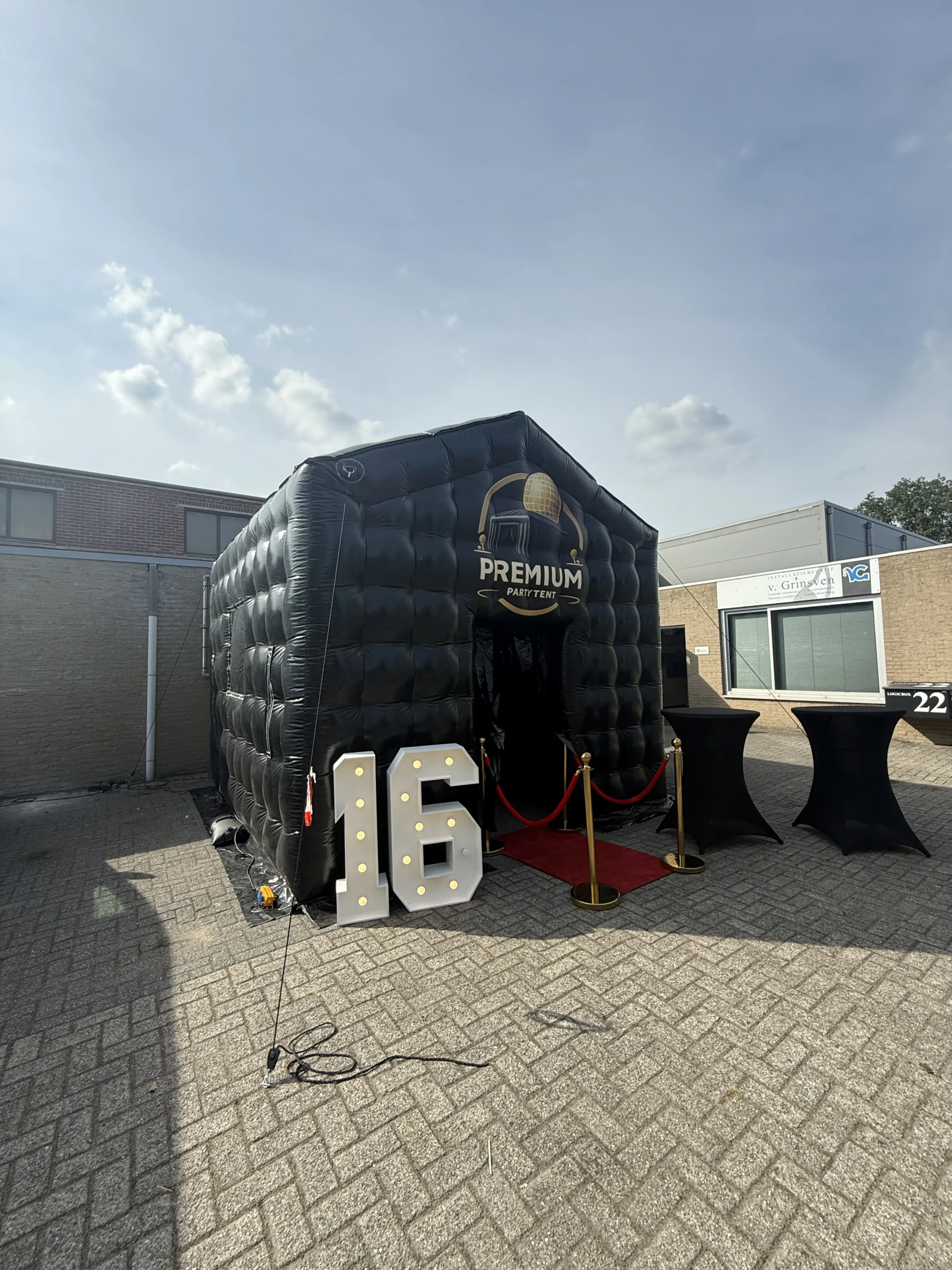 Velsen - een luxe zwarte opblaasbare partytent op een parkeerplaats met twee lichtcijfers