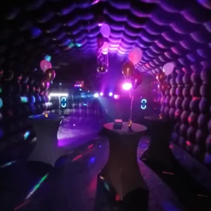Discotent van binnen met statafels, ballonnen en paarse sfeerverlichting